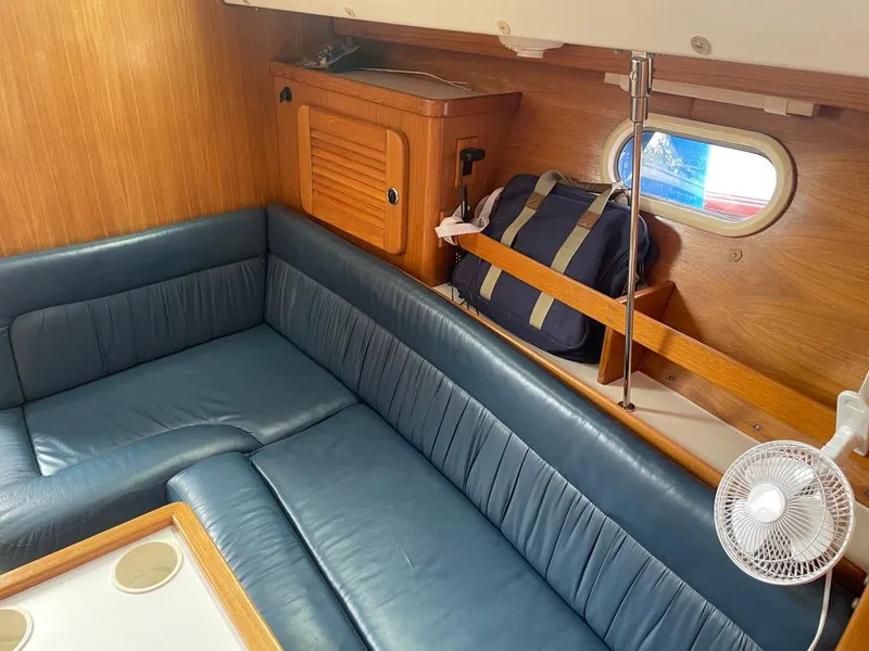 Slide: The Image of Interior of 2000 Catalina 310 sailboat with blue seating and wooden accents. - 44