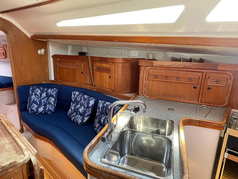 Slide: The Image of Interior of a 2001 C&C 110 sailboat with blue seating and wooden cabinetry. - 18