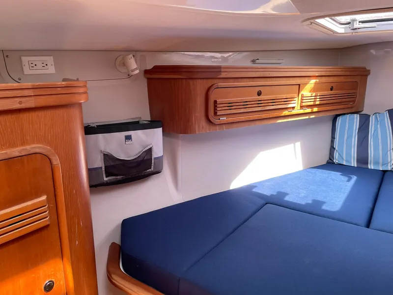 Slide: The Image of Interior cabin of a 2001 C&C 110 sailboat with blue cushions and wooden storage. - 24