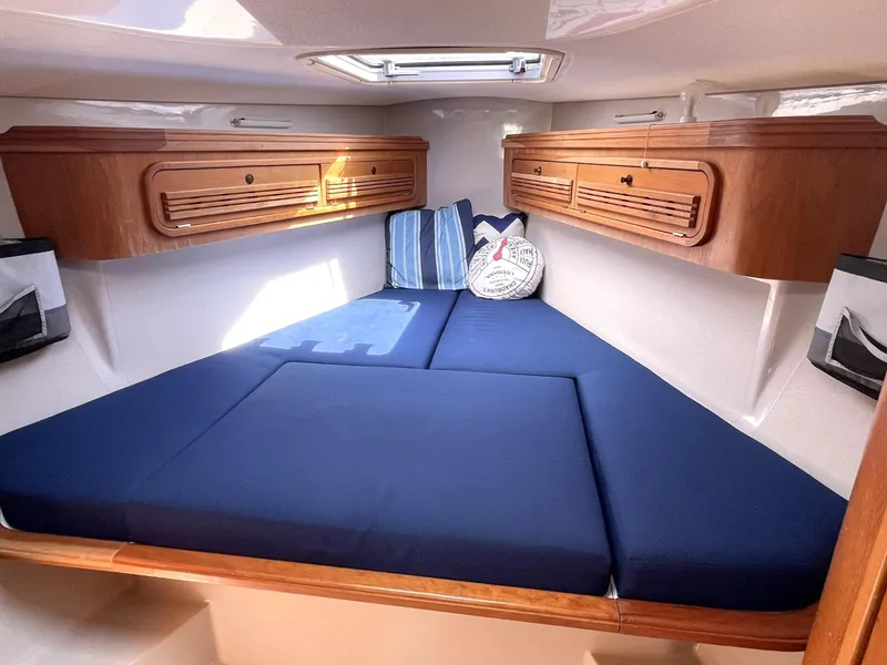 Slide: The Image of C&C 110 2001 sailboat interior with blue cushions and wooden cabinets. - 26