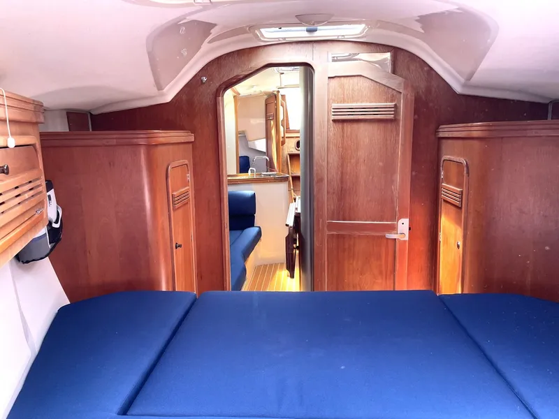 Slide: The Image of Interior of a 2001 C&C 110 sailboat with blue cushions and wooden cabinetry. - 27