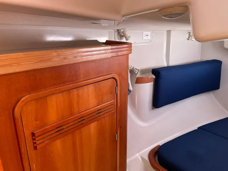 Slide: The Image of Interior cabin of a 2001 C&C 110 sailboat with wooden cabinetry and blue cushions. - 30