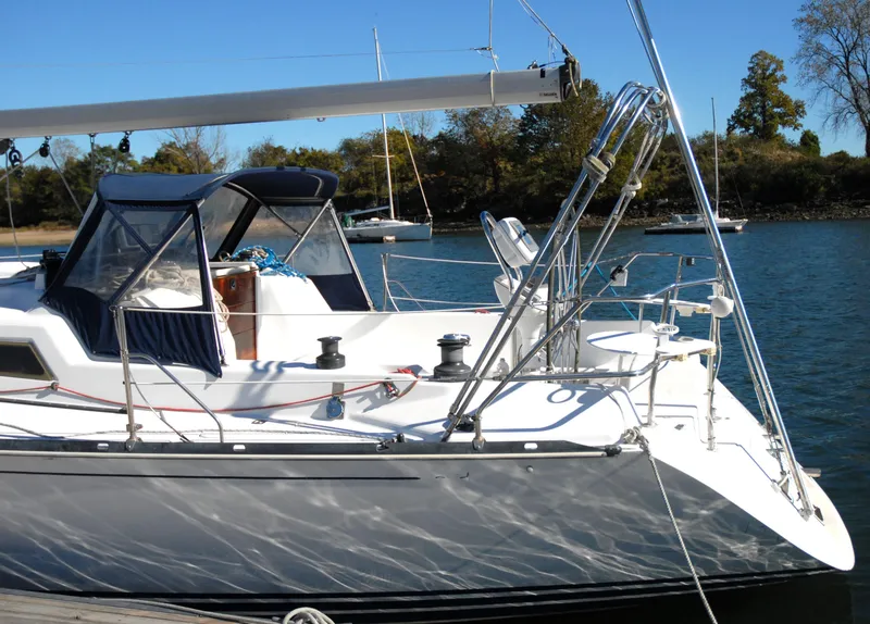 Slide: The Image of C&C 110 sailboat docked, 2001 model, with blue canopy and clear skies. - 5