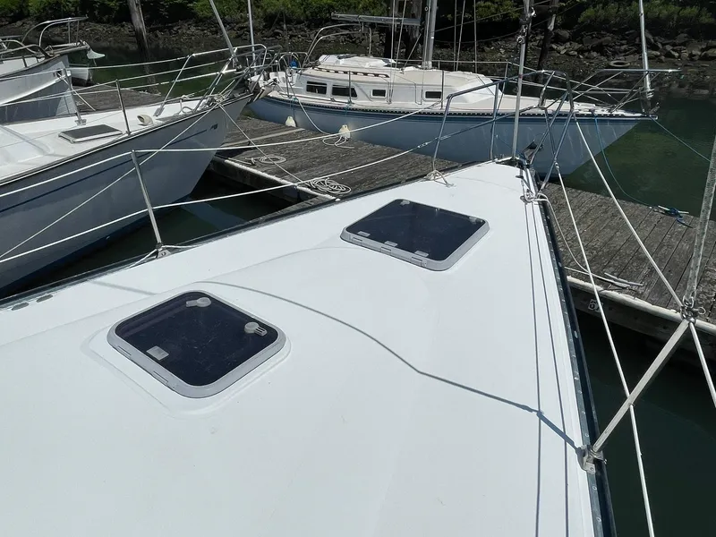 Slide: The Image of C&C 110 sailboat (2001) docked, showing deck hatches and railing. - 7