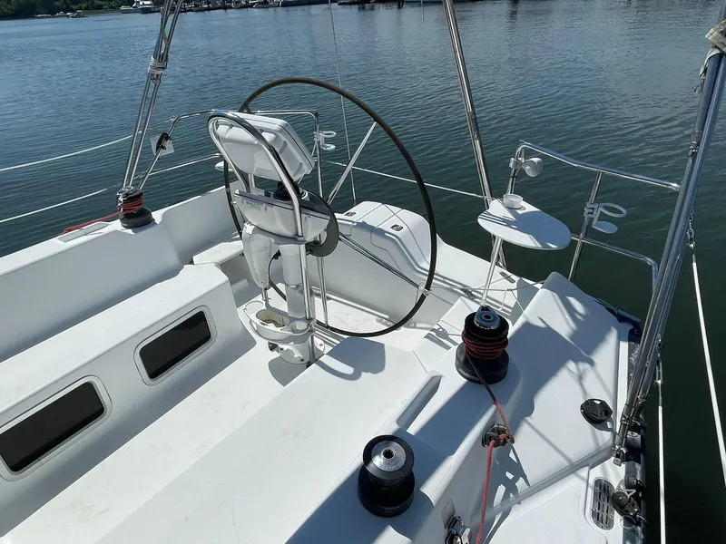 Slide: The Image of C&C 110 sailboat cockpit, 2001 model, with steering wheel and winches, docked on calm water. - 9