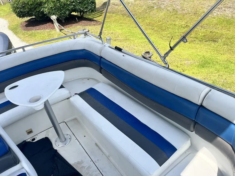 Slide: The Image of 1995 Hurricane FunDeck 240 boat interior with blue and white seating and a small table. - 16