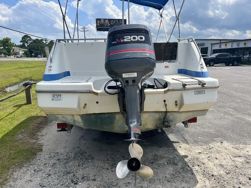 Slide: The Image of 1995 Hurricane FunDeck 240 boat with Yamaha V6 200 outboard motor, parked on gravel. - 4