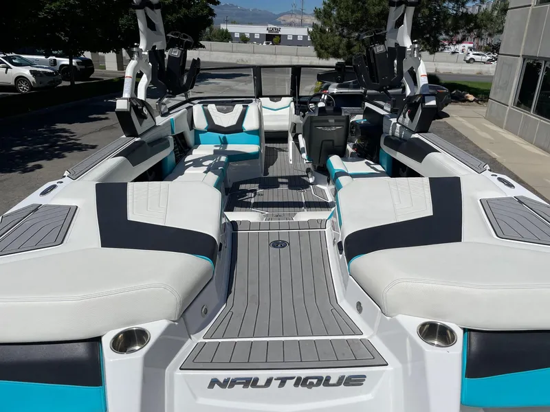 Slide: The Image of 2021 Nautique Super Air Nautique G25 boat interior with white and teal seating. - 6