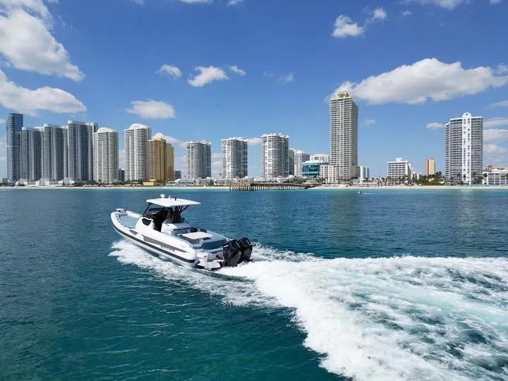 Slide: The Image of Ranieri CAYMAN 38.0 EXECUTIVE 2025 cruising near a city skyline on a sunny day. - 8