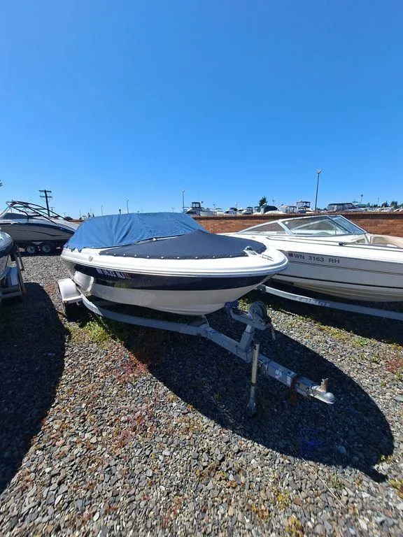 Slide: The Image of 2001 Bayliner 185 Capri Sport BR boat on a trailer, covered and parked outdoors. - 4