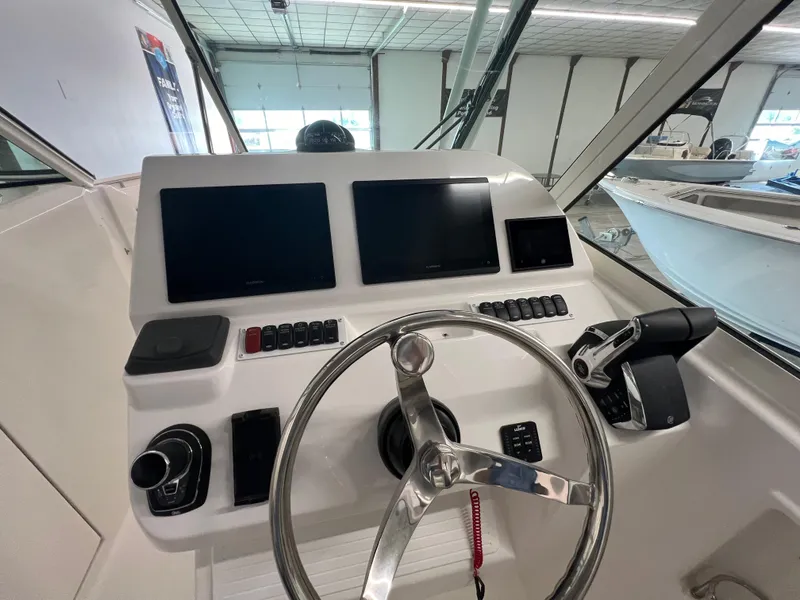 Slide: The Image of 2025 Albemarle 27 Dual Console boat helm with dual screens and steering wheel. - 11
