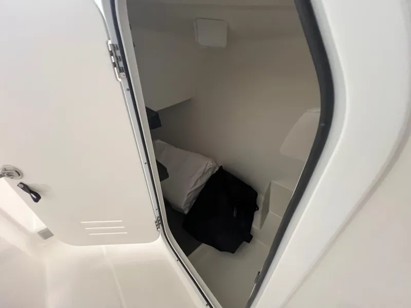 Slide: The Image of 2025 Albemarle 27 Dual Console cabin interior with bedding and storage. - 16