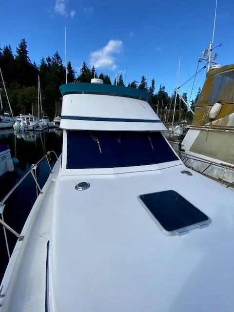 Slide: The Image of 1997 Norstar 302 boat docked in a marina, surrounded by other vessels and trees. - 15
