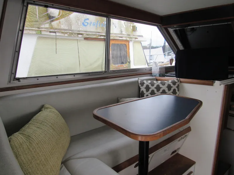 Slide: The Image of Cozy interior of 1997 Norstar 302 boat with cushioned seating and table. - 24