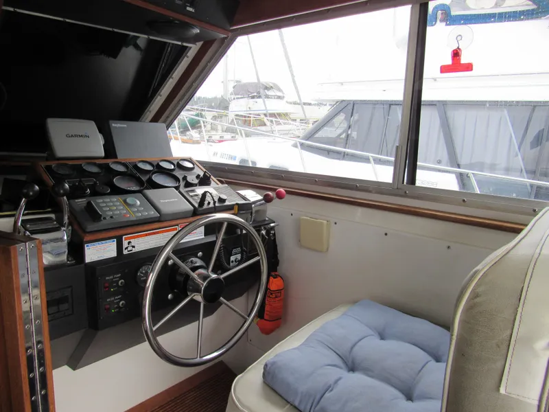 Slide: The Image of 1997 Norstar 302 boat cockpit with steering wheel, gauges, and cushioned seat. - 25
