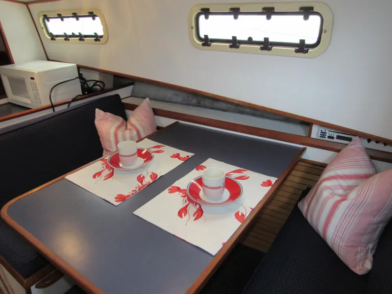 Slide: The Image of 1997 Norstar 302 interior dining area with table settings and striped cushions. - 27