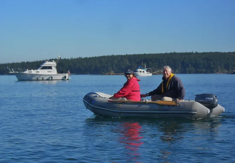 Slide: The Image of Two people in a small boat on a lake, with a yacht in the background. - 41