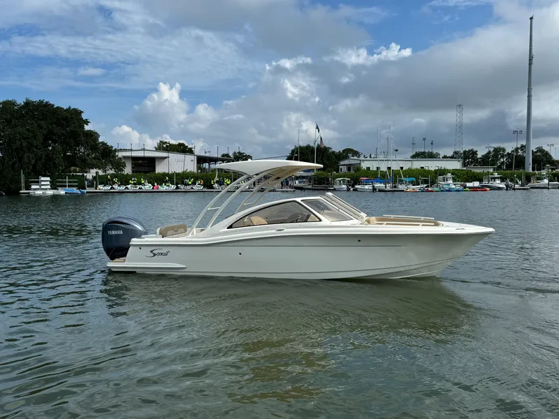 Slide: The Image of 2024 Scout 240 Dorado boat on calm water with marina background. - 1
