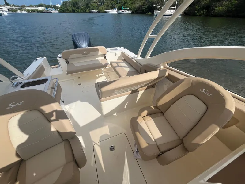 Slide: The Image of 2024 Scout 240 Dorado boat interior with beige seating, on a calm water body. - 16