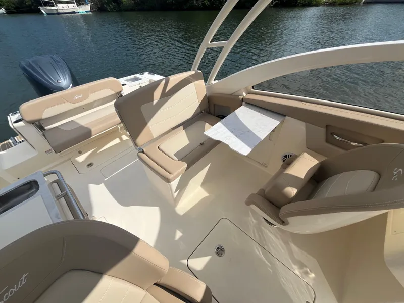Slide: The Image of 2024 Scout 240 Dorado boat interior with beige seating and water view. - 17