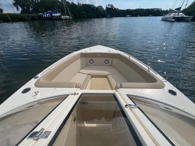 Slide: The Image of 2024 Scout 240 Dorado boat with open bow seating on a calm lake. - 20