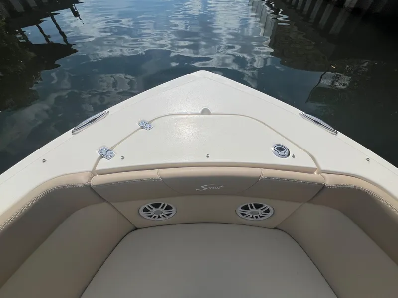 Slide: The Image of 2024 Scout 240 Dorado boat bow with seating and speakers on calm water. - 28