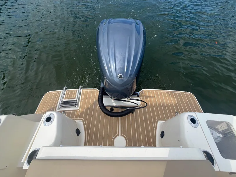Slide: The Image of 2024 Scout 240 Dorado boat stern with outboard motor on water. - 6