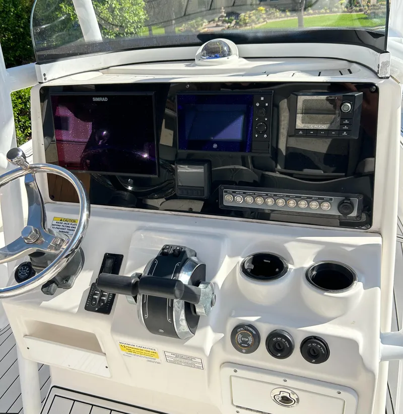 Slide: The Image of Helm of 2018 Tidewater 2700 Carolina Bay boat with navigation controls and displays. - 10