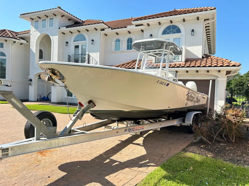 Slide: The Image of 2018 Tidewater 2700 Carolina Bay boat on trailer in front of luxury house. - 23