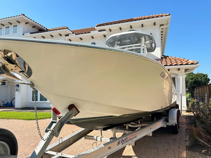 Slide: The Image of 2018 Tidewater 2700 Carolina Bay boat on trailer in front of house. - 27