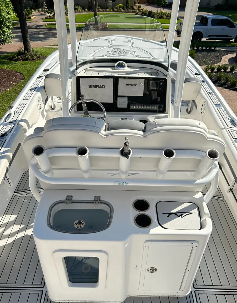 Slide: The Image of 2018 Tidewater 2700 Carolina Bay boat interior with helm, seating, and fishing rod holders. - 8