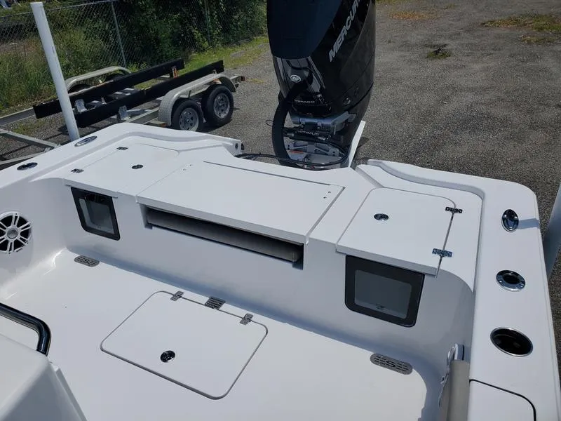 Slide: The Image of 2024 Sportsman Masters 267OE Bay boat stern with storage compartments and Mercury outboard motor. - 11