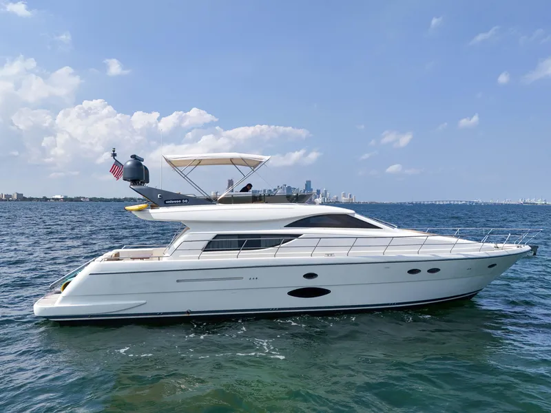 The Image of 2006 Uniesse 58 yacht cruising on a sunny day with city skyline in the background. - 0
