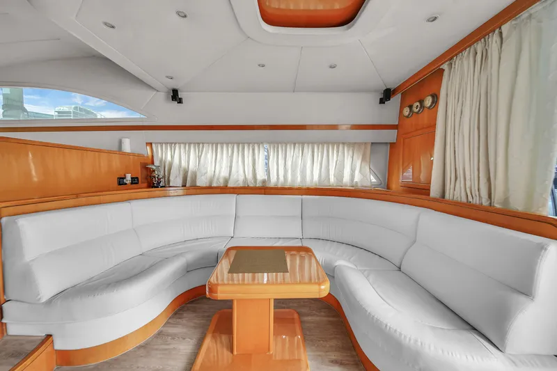 Slide: The Image of Luxurious interior of a 2006 Uniesse 58 yacht with white leather seating and wooden table. - 14