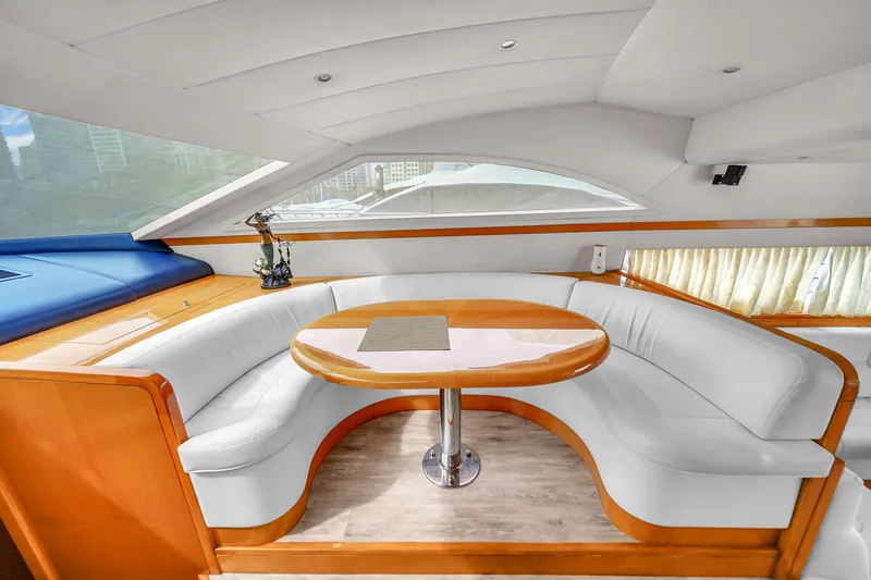 Slide: The Image of 2006 Uniesse 58 yacht interior with curved white seating and wooden table. - 19