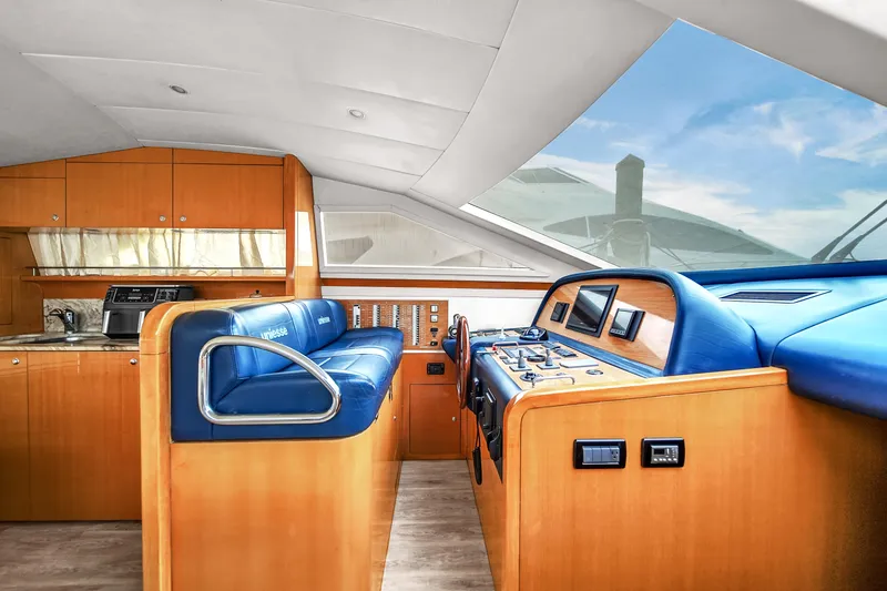 Slide: The Image of Interior of 2006 Uniesse 58 yacht with blue leather seating and wooden cabinetry. - 22