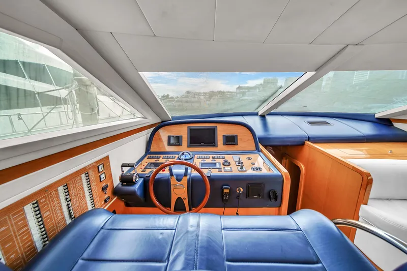 Slide: The Image of 2006 Uniesse 58 yacht cockpit with blue leather seats and modern control panel. - 24