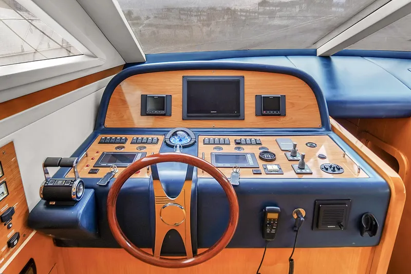 Slide: The Image of Helm station of 2006 Uniesse 58 yacht with wooden steering wheel and navigation instruments. - 25