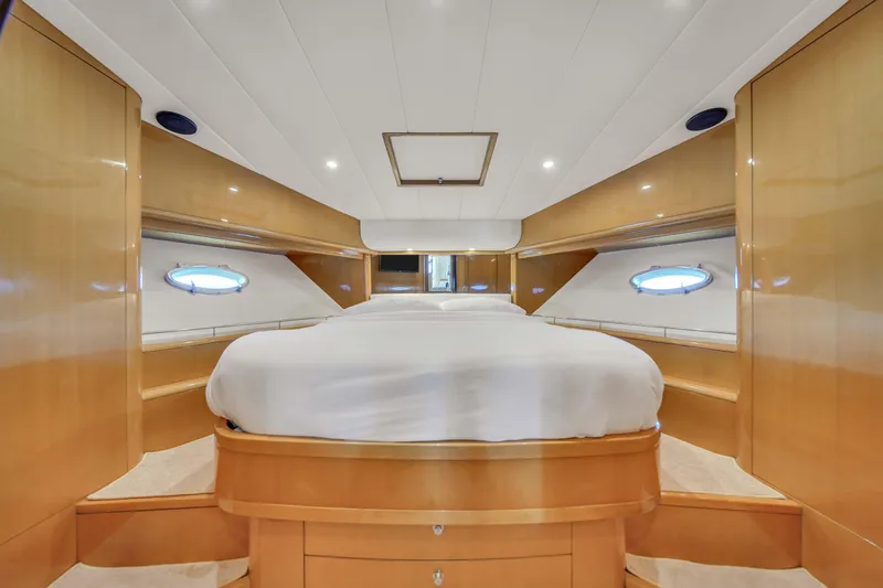 Slide: The Image of Luxurious master cabin in a 2006 Uniesse 58 yacht with wood paneling and porthole windows. - 31