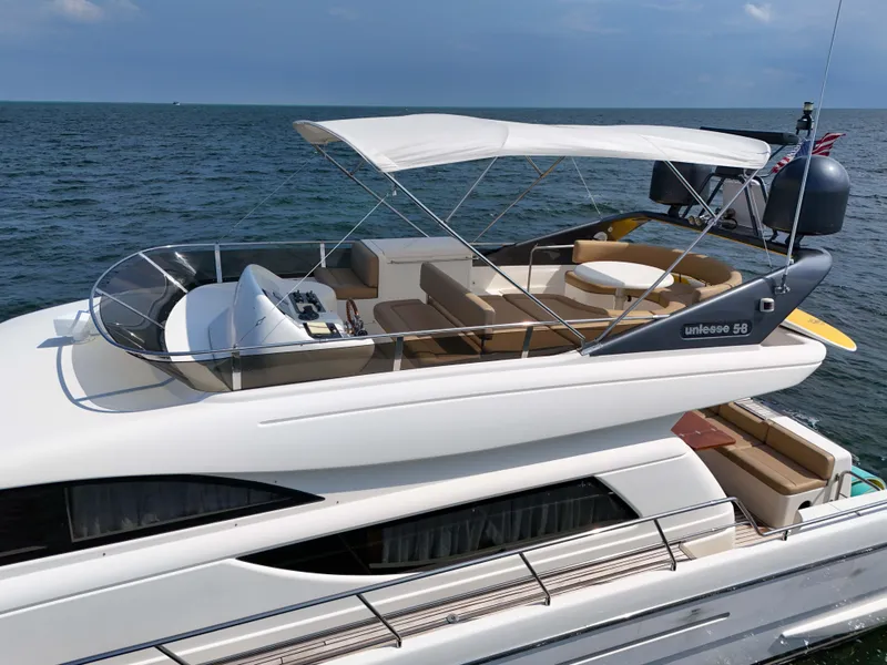 Slide: The Image of 2006 Uniesse 58 yacht with spacious deck and canopy on open water. - 9