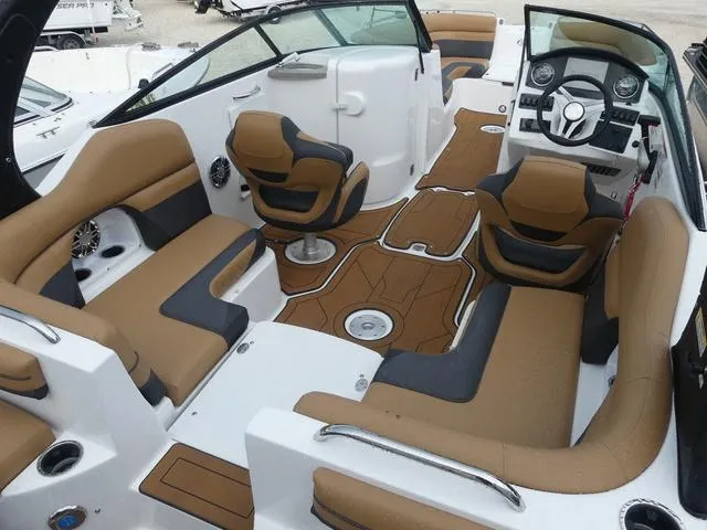 Slide: The Image of 2024 Hurricane SunDeck 2486 OB boat interior with brown and black seating, modern dashboard, and spacious layout. - 9