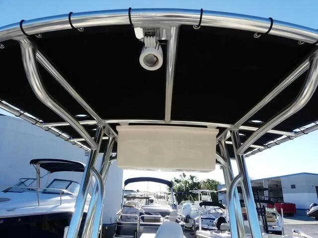 Slide: The Image of 2024 Bulls Bay 2200 boat with T-top and mounted light, docked among other boats. - 15
