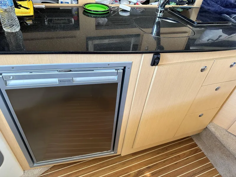 Slide: The Image of Compact kitchen area in a 2012 Bayliner 335 Cruiser with a Dometic fridge. - 16