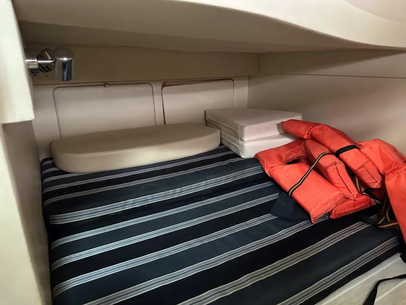 Slide: The Image of Interior cabin of 2012 Bayliner 335 Cruiser with striped bedding and life jackets. - 19