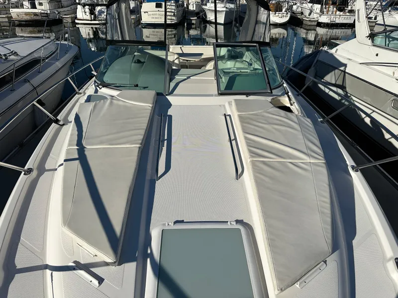 Slide: The Image of 2012 Bayliner 335 Cruiser boat with sun pads docked at marina. - 2
