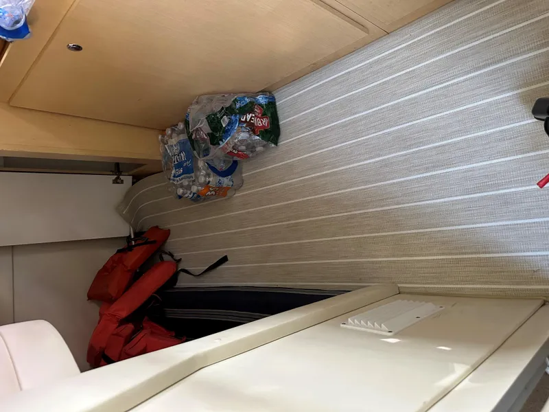 Slide: The Image of Interior of 2012 Bayliner 335 Cruiser with life jackets and bottled water storage. - 26