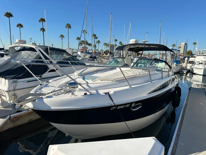 Slide: The Image of 2012 Bayliner 335 Cruiser docked at a marina with other boats. - 30