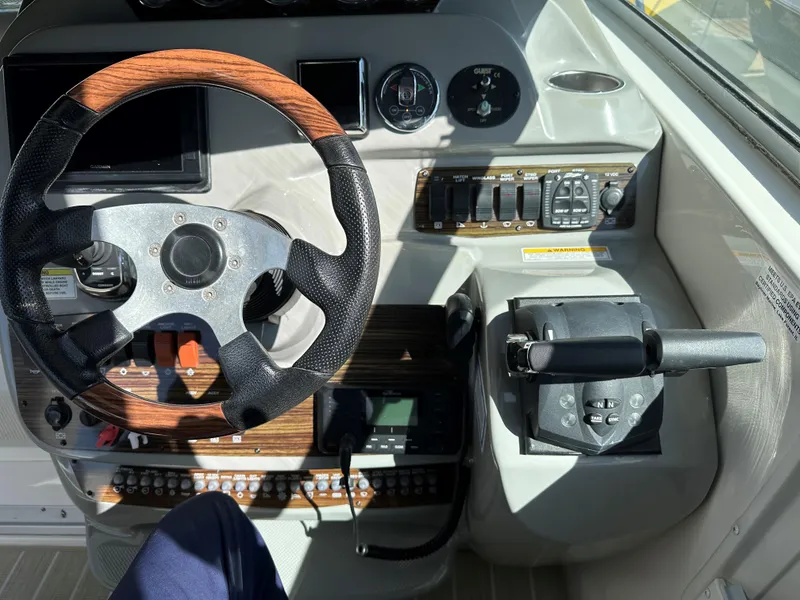 Slide: The Image of 2012 Bayliner 335 Cruiser helm with wood-accented steering wheel and control panel. - 8