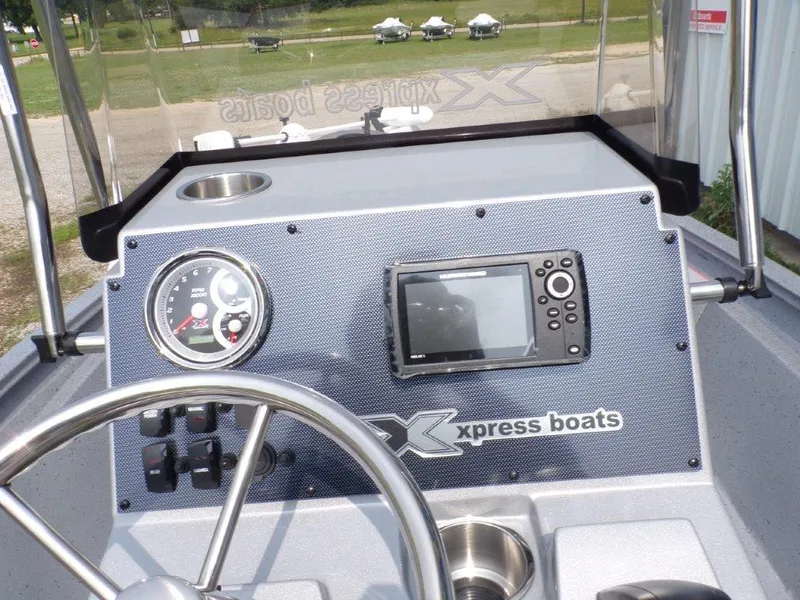 Slide: The Image of 2024 Xpress H190Bay boat dashboard with steering wheel, gauges, and navigation system. - 10
