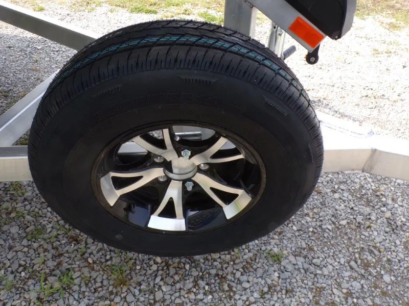 Slide: The Image of 2024 Xpress H190Bay trailer tire on gravel surface. - 16